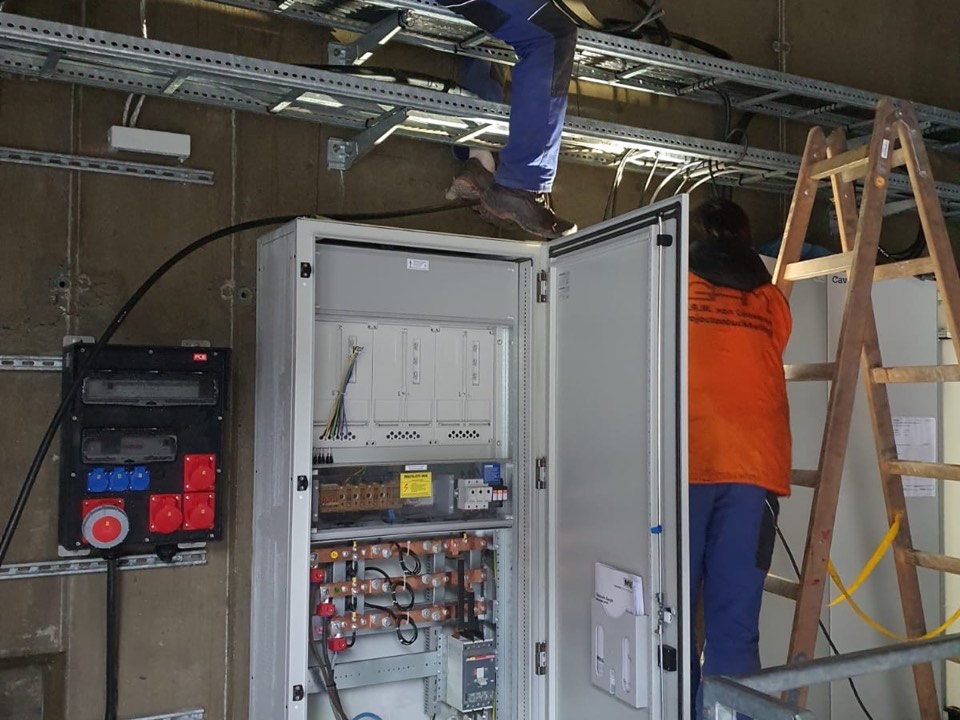 COME WORKS electrician working on a distribution cabinet on site