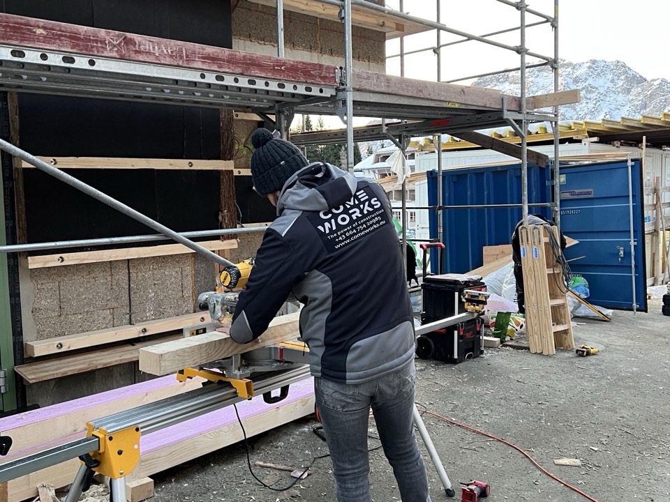 COME WORKS carpenter cutting timber on a construction site